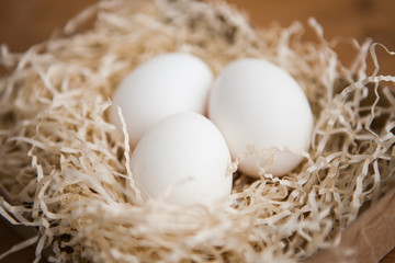 Three white eggs in the nest, close up