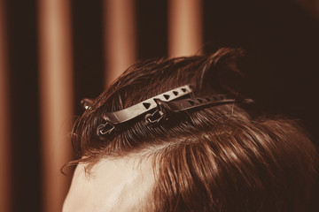 Fototapeta premium Close up. Styling client haircut with hair clips in Barber shop