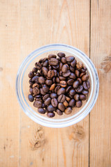Coffee beans in the pot on a wood ground