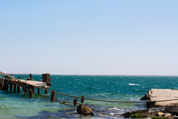 Fototapeta premium destroyed pier at the black sea coast spit Belyaus in the summer bright warm day