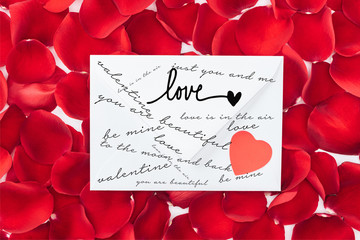 top view of envelope with love, heart and red rose petals on background, st valentines day concept