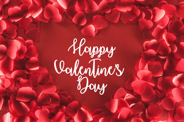 top view of beautiful heart shaped frame from decorative petals on red background with "Happy valentines day" lettering