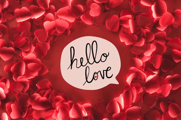 top view of beautiful round frame from decorative heart shaped petals on red background with "hello love" lettering, valentines day concept