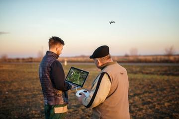 Technician farmer use wifi computer control agriculture drone on field 