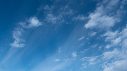 Fototapeta na wymiar Cirrus clouds scattered in a clear blue sky.