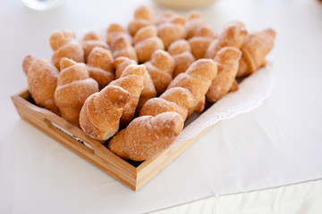 Basket with tasty croissants on white table