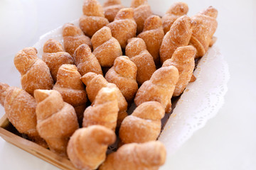 Basket with tasty croissants on white table