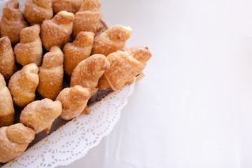 Basket with tasty croissants on white table