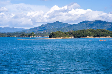 Many small islands over the blue ocean in sunny day, famous Kujukushima(99 islands) pearl sea resort islet in Sasebo Saikai National Park, Nagasaki, Kyushu, Japan.