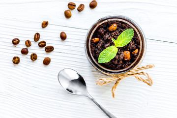 Body scrub of ground coffee on white table background top view