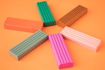colored plasticine on on orange background