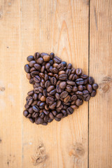 Heart from coffee beans on a wood ground