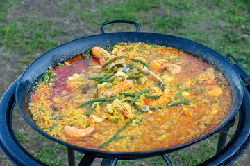 A large pan of seafood paella outdoors