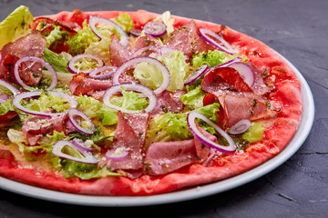 Homemade pizza with tomatoes, beef, pepper and red onion