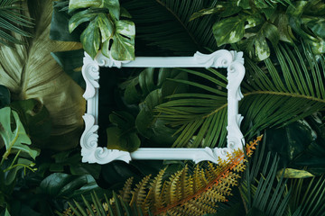 Creative layout made of tropical leaves with vintage frame. Flat lay. Nature concept.