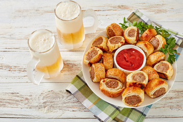 sausage rolls with tomato sauce and beer