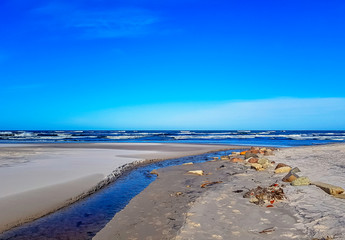 Fresh water stream going into the Baltic Sea in winter - Lubiatowo, Pomerania, Poland