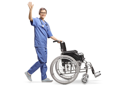 Young Female Nurse Pushing An Empty Wheelchair And Waving