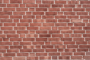 Background from a wall with red bricks of different shades and jointing