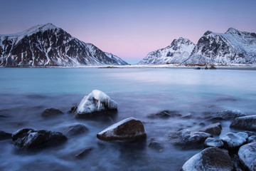 Beautiful landscape view with water in motion and mountain in background. Lofoten, Norway