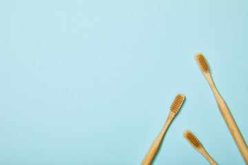 top view of bamboo toothbrushes on blue background