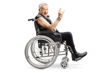 Mature man in a wheelchair making a rock and roll hand sign and looking at the camera