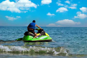 Fototapeta na wymiar Tourists enjoy driving jetski on the ocean, Space for text. Hot summer time