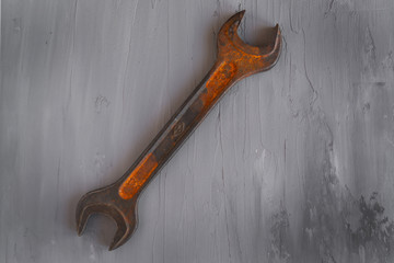 old rusty wrench on concrete bakground