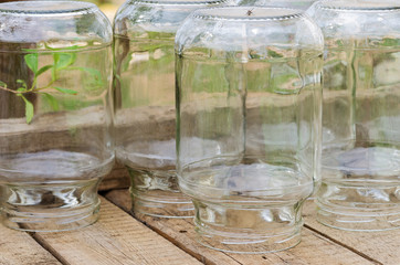 Three-liter glass banks on wooden boards. Glass jars for home pickles in the courtyard of a village house