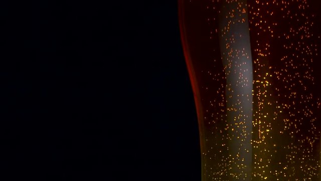Close-up big transparent glass bocal refreshment cooled golden beer with many air bubbles rising up isolated at black background. Alcohol beverage bubbles yellow particle animation static shot slowmo