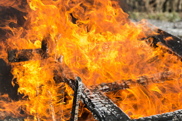 The old wooden house burns. Fire close-up, the boards are burning