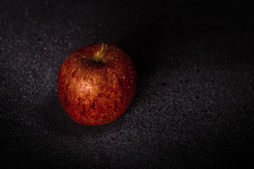 Red Apple on dark background with water drops