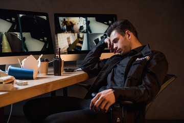 guard in black uniform sleeping at workplace