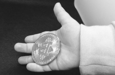Bitcoin coin in child's hand, close-up