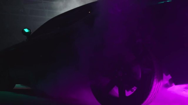 Silhouette of beautiful american muscle car on smoked dark background . Car lights on fog . 