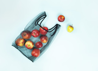 Top view of apples in a reusable string bag. Sustainable eco packaging concept: shopping for groceries with a multi-use bag to reduce ecological footprint