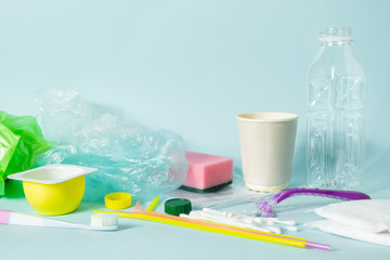 Plastic waste concept: variety of single use objects that get thrown out every day. Plastic bottle, hygiene items and plastic package depicting ecological footprint of an everage person.