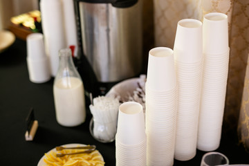 Fototapeta na wymiar Stacks of wite paper cups, hot coffee cups, beverage cups on coffee machine in cafe