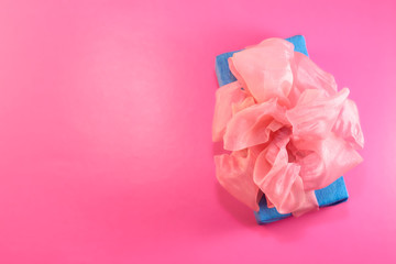 The gift is packed and decorated with a pink bow on a pink background with copy space. Flat lay, top view. copy space