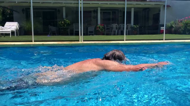 Older Man Swimming At Home Pool Outdoors