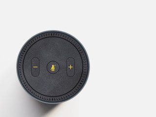 Black Wireless Smart Speaker and Voice Assistant Device, Viewed from Above, with Yellow Buttons.