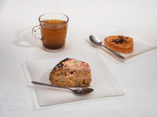 Delicious dessert with a slice of cake and jelly, homemade on a white table.