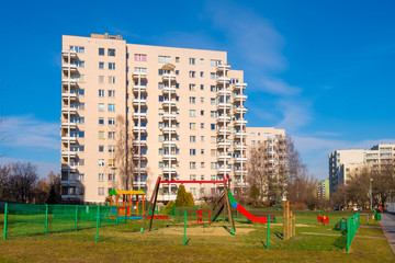 Fototapeta na wymiar Warsaw, Poland - Sluzew nad Dolinka district with large scale residential architecture and children playground facilities in early spring season.