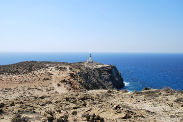 Fototapeta na wymiar View of the lighthouse on a stone cliff above the sea against the sky, Prasonisi, Rhodes island, Greece