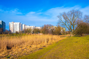 Warsaw, Poland - Dolina Sluzewiecka valley and public park along the Potok Sluzewiecki creek with Mokotow and Sluzew nad Dolinka districts residential architecture in early spring season.