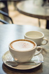 Hot coffee and hot tea place on the marble table in early morning with copyspace, white cup and silver spoon.