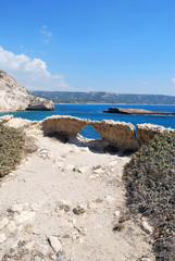 The ruins of stone caves on the background of the island and blue sky, Cape Fourni, Rhodes Island, Greece