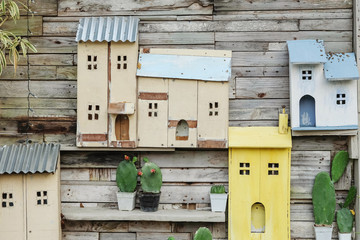Closeup decoration on old wood wall of house by cactus and wooden box in house shape