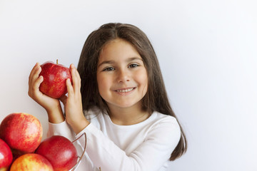 Happy cute child girl eating fresh apples. Vitamins and healthy nutrition. Beautiful face. Healthy teeth.