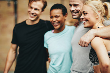 Smiling group of diverse friends standing together in a gym